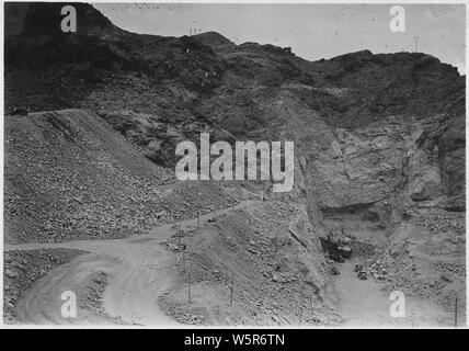 Auf der Suche nach in die Baugrube für das Arizona Abflußkanal. Hohe links ist Start- und Landebahn für sechs Unternehmen "Bau der Seilbahn, die die normale Höhe von 1360 am fernen Ende Überhang erreicht hat in fernen Ende von Schnittmarken die Neigung konvertieren Der spillway Tunnels.; Umfang und Inhalt: Foto aus Band 2 einer Reihe von Fotoalben dokumentiert den Bau des Hoover Dam, Boulder City, Nevada gesehen. Stockfoto