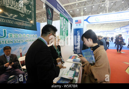 ------ Chinesischer Besucher sprechen mit Ausbildung Berater am Stand der Vereinigten Staaten während einer Expo in Peking, China, 24. März 2018. Chinesisch Stockfoto