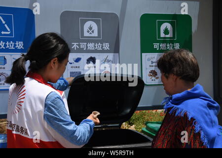 Eine chinesische Freiwillige stellt Müll sortieren zu einem Dorfbewohner in Dongchu Dorf, Stadt Rongcheng, Provinz Shandong im Osten Chinas, 4. Juni 2019. Variou Stockfoto