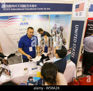 ------ Chinesischer Besucher sprechen mit Ausbildung Berater am Stand der Vereinigten Staaten während einer Expo in Peking, China, 23. März 2019. Chinesisch Stockfoto