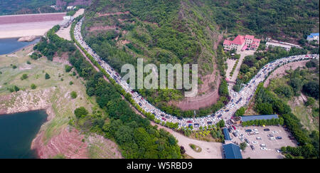 Autos fahren Sie langsam auf der Straße, wie sie sich vorbereiten, die Landschaft von Wasser durch den Xiaolangdi Dam für Hochwasserschutz auf dem Gelben Fluss zu genießen Stockfoto