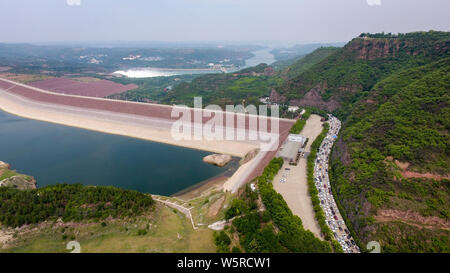 Autos fahren Sie langsam auf der Straße, wie sie sich vorbereiten, die Landschaft von Wasser durch den Xiaolangdi Dam für Hochwasserschutz auf dem Gelben Fluss zu genießen Stockfoto