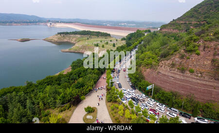 Autos fahren Sie langsam auf der Straße, wie sie sich vorbereiten, die Landschaft von Wasser durch den Xiaolangdi Dam für Hochwasserschutz auf dem Gelben Fluss zu genießen Stockfoto