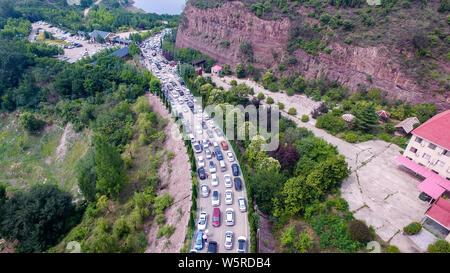 Autos fahren Sie langsam auf der Straße, wie sie sich vorbereiten, die Landschaft von Wasser durch den Xiaolangdi Dam für Hochwasserschutz auf dem Gelben Fluss zu genießen Stockfoto