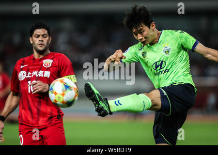 Kim Jin-su, rechts, von Südkorea der Jeonbuk Hyundai Motors FC passt den Ball gegen den brasilianischen Fußballspieler Givanildo Vieira de Sousa, bekannt als Hu Stockfoto