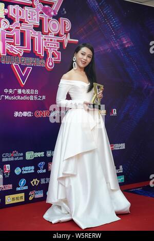 Singaporean Sänger und Songwriter Tanya Chua stellt mit ihrer Trophäe, nachdem er das "Beste Sängerin" während der Musik 2018 Radio China Top Chart Stockfoto