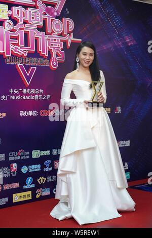 Singaporean Sänger und Songwriter Tanya Chua stellt mit ihrer Trophäe, nachdem er das "Beste Sängerin" während der Musik 2018 Radio China Top Chart Stockfoto