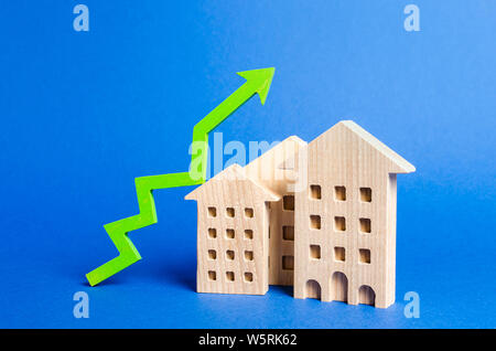 Zahlen von Wohngebäuden und grünen Pfeil nach oben. Steigende Wert und Preis. Apartments zum Verkauf. Wachstum der Nachfrage und Liquidität für Immobilien, erhöh Stockfoto