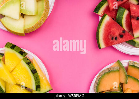 Wassermelone und Honigmelone Schichten auf Platte, Ansicht von oben auf Rosa Pastell Hintergrund, Flach. Stockfoto
