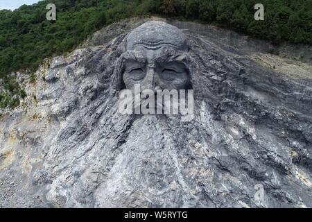 Die riesige Skulptur von Fuxi, eine Kultur, Held in chinesischen Legenden und Mythologie, wird aus Stein an einem verlassenen Steinbruch in Xiangyang Stadt geschnitzt, Stockfoto