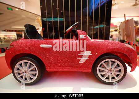 ---- Ein Kind, fahrbereite Mercedes-Benz besetzt mit Swarovski Kristallen ist das Flaggschiff der FAO Schwarz Store in Peking, China, 31 angezeigt Stockfoto