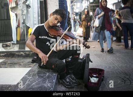 Tonekabon, Iran. 29. Juli, 2019. Ein junger Mann spielt die Geige auf einer Straße in Tonekabon Stadt, nördlichen Iran, 29. Juli 2019. Credit: Ahmad Halabisaz/Xinhua/Alamy leben Nachrichten Stockfoto