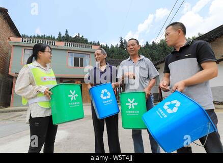 Eine chinesische Freiwillige stellt Müll sortieren Dorfbewohner in Gulong Dorf, Rong'an county, Liuzhou, South China Guangxi Zhuang autonomen R Stockfoto