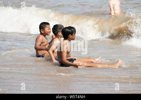 Warmes Wetter in Skegness. Jungen spielen in den Wellen auf Skegness Beach Stockfoto