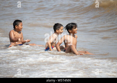 Warmes Wetter in Skegness. Jungen spielen in den Wellen auf Skegness Beach Stockfoto