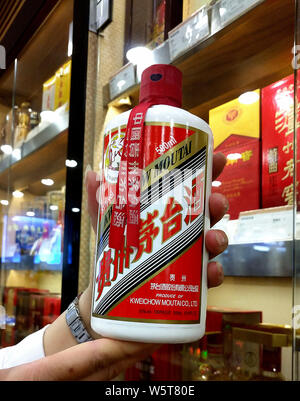 ---- Ein Kunde Geschäfte für eine Flasche chinesischen Schnaps Teekocher Kweichow Moutai in einem Supermarkt in Shenzhen, der südchinesischen Provinz Guangdong, 27. Stockfoto