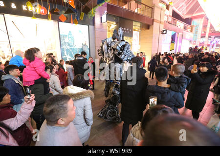 Ein Student trägt einen zwei Meter hohen lebensgroße Nachbildung von Optimus Prime ist seitens der Kunden in ein Einkaufszentrum in der Stadt Xi'an, Northwest C umgeben Stockfoto