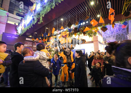 Ein Student trägt einen zwei Meter hohen lebensgroße Nachbildung von Hummel ist seitens der Kunden in ein Einkaufszentrum in der Stadt Xi'an im Nordwesten Chinas umgeben Stockfoto