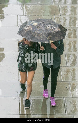 London, Großbritannien. 30. Juli 2019. Fußgänger Schutz vor dem Regen in Waterloo, als einem Monat Niederschlag ist voraussichtlich in drei Stunden Kredit zu fallen: Amer ghazzal/Alamy leben Nachrichten Stockfoto