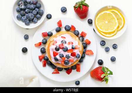 Pfannkuchen mit Früchten Joghurt, frische Erdbeeren und Heidelbeeren, Ansicht von oben Stockfoto