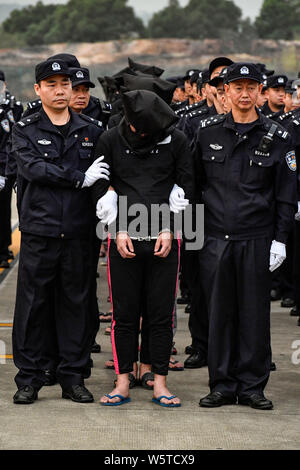 Chinesische Verdächtige für Cross-border telecom Betrug durch chinesische Polizisten begleitet, wie sie sich aus Kambodscha zurück und kommen an der Stockfoto