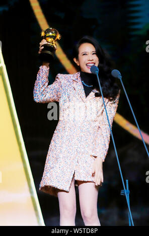 Hong Kong Sängerin und Schauspielerin Karen Mok wirft mit der Trophäe für den 'Most Beliebte Sängerin (Hongkong/Taiwan)' Award am 12. migu Musik Awar Stockfoto
