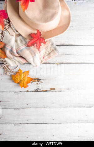 Herbst Komposition. Frauen Filzhut, plaid Decke, im Herbst rot gelb orange Blätter, Holz- alte Tabelle, kopieren Raum Stockfoto
