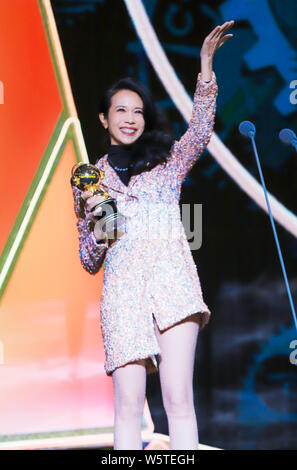 Hong Kong Sängerin und Schauspielerin Karen Mok wirft mit der Trophäe für den 'Most Beliebte Sängerin (Hongkong/Taiwan)' Award am 12. migu Musik Awar Stockfoto