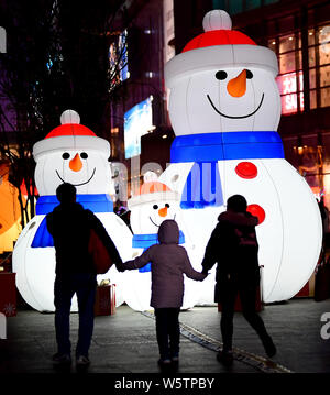 Riesige beleuchtete Dekorationen mit der Form der Schneemänner sind angezeigt das bevorstehende Weihnachtsfest vor einem Einkaufszentrum in Sheny zu markieren Stockfoto