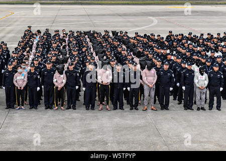 Chinesische Verdächtige für Cross-border telecom Betrug durch chinesische Polizisten begleitet, wie sie sich aus Kambodscha zurück und kommen an der Stockfoto