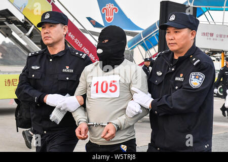 Chinesische Verdächtige für Cross-border telecom Betrug durch chinesische Polizisten begleitet, wie sie sich aus Kambodscha zurück und kommen an der Stockfoto