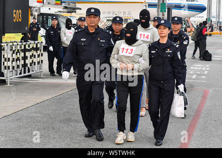 Chinesische Verdächtige für Cross-border telecom Betrug durch chinesische Polizisten begleitet, wie sie sich aus Kambodscha zurück und kommen an der Stockfoto