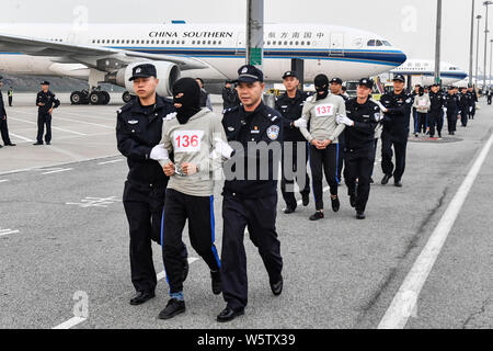 Chinesische Verdächtige für Cross-border telecom Betrug durch chinesische Polizisten begleitet, wie sie sich aus Kambodscha zurück und kommen an der Stockfoto