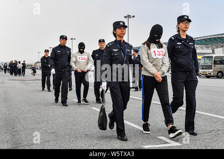 Chinesische Verdächtige für Cross-border telecom Betrug durch chinesische Polizisten begleitet, wie sie sich aus Kambodscha zurück und kommen an der Stockfoto