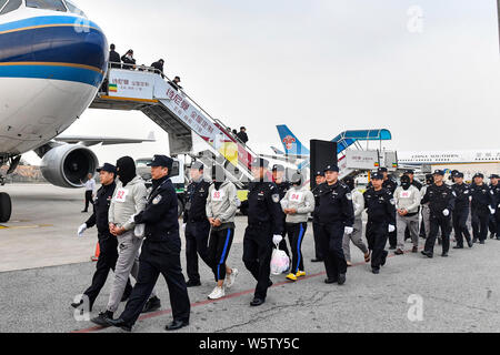 Chinesische Verdächtige für Cross-border telecom Betrug durch chinesische Polizisten begleitet, wie sie sich aus Kambodscha zurück und kommen an der Stockfoto