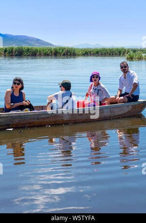 Cay, Afyonkarahisar/Turkey-June 30 2019: Touristen auf Fischerboot in einem ruhigen See Wasser. Altes, hölzernes Fischerboot. Angeln Boot am See Eber. Stockfoto