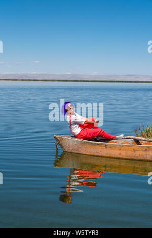 Cay, Afyonkarahisar/Turkey-June 30 2019: Fancy Girl Posen auf Fischerboot in einem ruhigen See Wasser. Altes, hölzernes Fischerboot. Angeln Boot am See Eber. Stockfoto