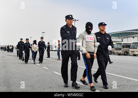 Chinesische Verdächtige für Cross-border telecom Betrug durch chinesische Polizisten begleitet, wie sie sich aus Kambodscha zurück und kommen an der Stockfoto