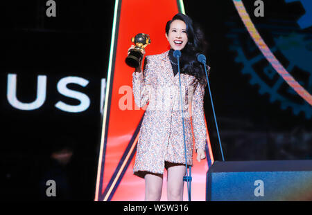 Hong Kong Sängerin und Schauspielerin Karen Mok wirft mit der Trophäe für den 'Most Beliebte Sängerin (Hongkong/Taiwan)' Award am 12. migu Musik Awar Stockfoto