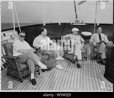 Foto von Präsident Truman und Mitglieder seines Personals entspannt auf dem Deck von seiner Yacht, die U.S.S. WILLIAMSBURG, während seinem Urlaub Kreuzfahrt nach Key West, Florida: (von links nach rechts) John R. Steelman, Assistent des Präsidenten; Charles Murphy, spezielle Berater des Präsidenten; Präsident Truman; Admiral Robert Dennison, Naval Berater des Präsidenten. Stockfoto