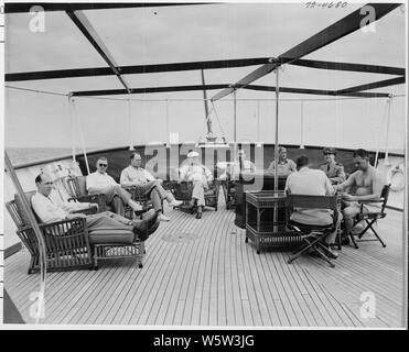 Foto von Präsident Truman und Mitglieder seiner Partei entspannen auf dem Achterdeck der Presidential Yacht, die U.S.S. WILLIAMSBURG, während Ferien Kreuzfahrt nach Key West, Florida: (von links nach rechts) David Stowe, Administrative, Assistent des Präsidenten; John Steelman, Assistent des Präsidenten; Charles Murphy, spezielle Berater des Präsidenten; Präsident Truman; Admiral Robert Dennison, Naval Berater des Präsidenten; Pressesprecher Charles Ross; Allgemeine Harry Vaughan, militärische Berater des Präsidenten (zurück in die Kamera); Kommandeur Donald MacDonald, kommandierender Offizier der Williamsburg; Gen. Robert Stockfoto