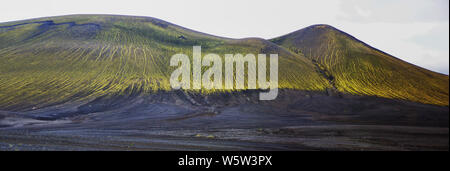 Herrliche vulkanische Landschaft auf dem Weg nach Landmannalaugar, Island. Schwarze vulkanische Asche von grünen Moosen bedeckt. Stockfoto