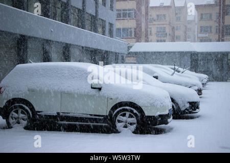 Autos sind mit Schnee bei starkem Schneefall in Weihai city bedeckt, der ostchinesischen Provinz Shandong, 7. Dezember 2018. Eine kalte Welle brachte eine schwere Schnee Stockfoto