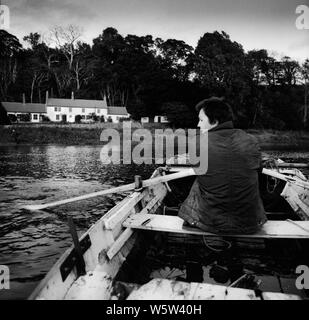 Colin Wharton rudern einen Schuß an Canny Fischerei auf dem Fluss Tweed an norham Bootshaus in den späten 1980er Jahren Stockfoto