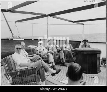 Foto von Präsident Truman und andere sich auf dem Achterdeck von seiner Yacht, die U.S.S. WILLIAMSBURG, während Ferien Kreuzfahrt von Washington nach Key West, Florida: (von links nach rechts) John R. Steelman, Assistent des Präsidenten; Charles Murphy, spezielle Berater des Präsidenten; Präsident Truman; Admiral Robert Dennison, Naval Berater des Präsidenten; Pressesprecher Charles Ross, Commander Donald MacDonald, kommandierender Offizier der Williamsburg. Stockfoto