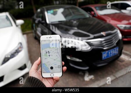 ---- Eine Chinesische Benutzer bereitet die TOGO App auf seinem Smartphone der QR-Code zum Scannen einer Roewe Auto des Fahrzeugs zu erhalten, Verwenden von File-sharing-service TOGO auf einer Straße Stockfoto