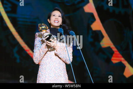 Hong Kong Sängerin und Schauspielerin Karen Mok wirft mit der Trophäe für den 'Most Beliebte Sängerin (Hongkong/Taiwan)' Award am 12. migu Musik Awar Stockfoto