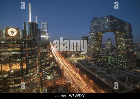 Eine Nacht im Central Business District (CBD) mit stark befahrenen Straßen mit Massen von Fahrzeugen, die die neuen CCTV-Turm und andere Wolkenkratzer und Hochhäuser bu Stockfoto