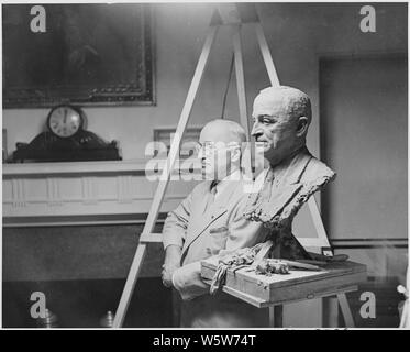 Foto von Präsident Truman neben einer Büste posiert, ein Werk des Bildhauers Nison Tregor, im Schaltschrank des Weißen Hauses. Stockfoto