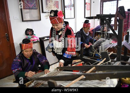 Chinesische Frau Liu Ying von Miao ethnische Gruppe beauftragt eine handwerkerin ein Kunstwerk von Miao Stickerei an Ihre Werkstatt in Kaili Stadt zu schaffen, im Südwesten von C Stockfoto